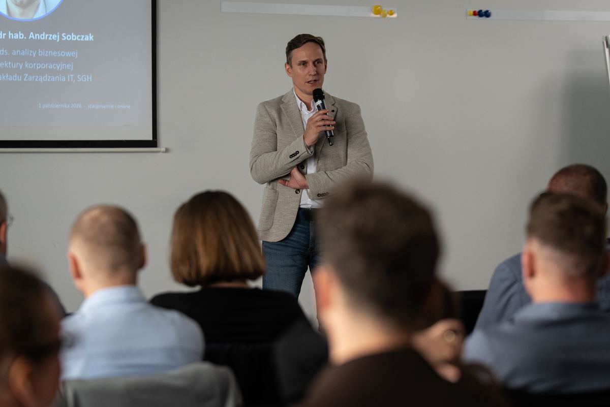 Wystąpienie z mikrofonem przed uczestnikami konferencji